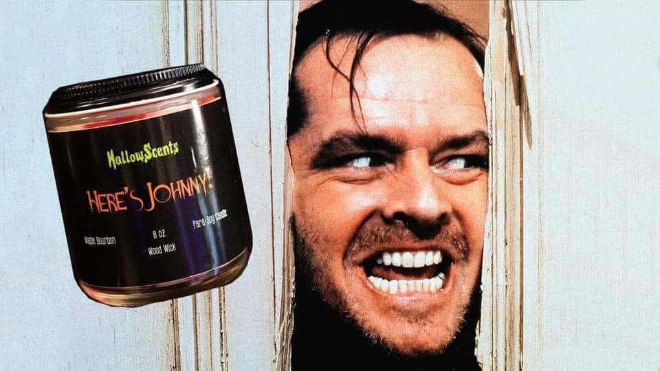 HallowsScents 'Here's Johnny!' candle with a close-up of a smiling man's face on a light blue background. 
Horror Wax Bars. Horror Candles. Spooky Wax Bars. Horror Candles. Horror Bath and Body. Spooky bath and body. 